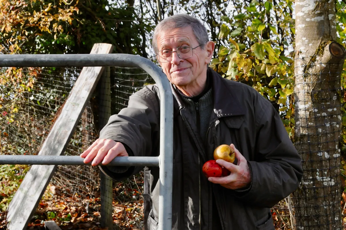 Man sieht Göpf Mülli, der das Tor zu seinem Obstgarten öffnet.